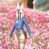 a woman wearing a blue sweater and bunny ears is standing in a field of pink flowers