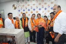 a group of people are posing for a picture in front of a wall that has the number 5 on it