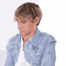 a man wearing a blue denim jacket and a white shirt