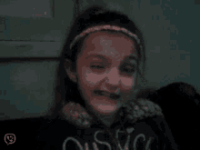 a little girl wearing a black shirt that says ' oasis ' on it