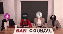 a group of people are sitting around a table with a sign that says ban council
