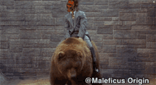 a man in a suit is riding on the back of a brown bear with maleficus origin written on the bottom