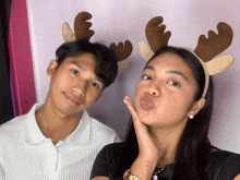 a man and a woman wearing reindeer antlers on their heads