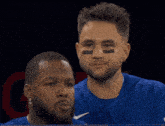 two baseball players are standing next to each other with one wearing a nike logo on his shirt