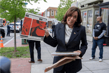 a woman is holding a newspaper with a picture of a man on it that says ' a man ' on it