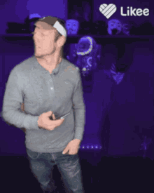 a man standing in front of a purple wall with a likee logo