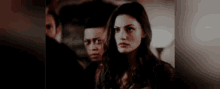 a man and a woman are standing next to each other and looking at the camera .