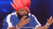 a man with a red wig on his head says i 'm feeling the vibe .