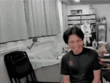 a man wearing a black shirt with the letter s on it is smiling