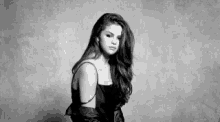 a black and white photo of a woman in a dress .