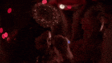a woman is dancing in a dark room with red lights .