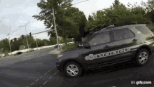 a police car is driving down a street .