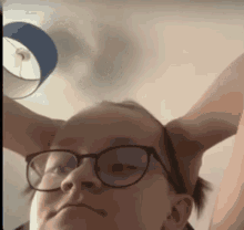 a close up of a person wearing glasses making a funny face