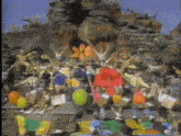 a group of people are gathered in front of a large rock formation with a sign that says ' a ' on it .