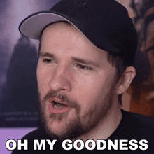 a man with a beard is wearing a black hat and says oh my goodness