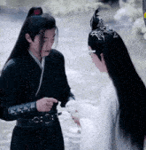 a man and a woman are standing next to each other and the man is holding a white rabbit