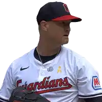 a man in a guardians jersey holds a glove