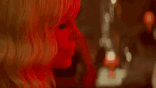 a close up of a woman 's face with the words `` bitch please '' written in neon lights behind her .