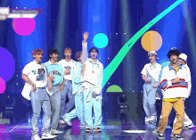 a group of young men are performing on a stage and one of them is wearing a shirt that says american