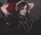 a woman is sitting in a chair wearing headphones and chains .