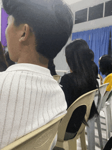 a group of people are sitting in a room and one of the chairs has the word gmc on it