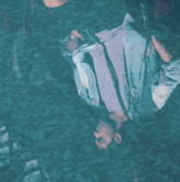 a person is swimming in a pool with a reflection of a person in it