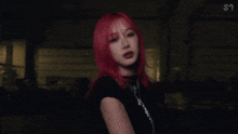 a girl with red hair is wearing a black shirt and a necklace