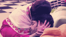 a woman kisses a man 's forehead while laying on the floor