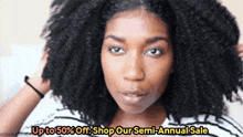 a woman with curly hair is advertising up to 50 % off shop our semi-annual sale