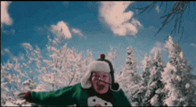 a person wearing a sweater with a snowman on it is standing in the snow with their arms outstretched