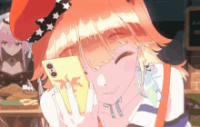 a girl with orange hair is smiling while holding a phone