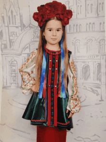 a little girl is wearing a traditional ukrainian outfit