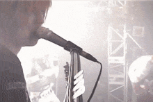 a man singing into a microphone while wearing a shirt that says bones on it