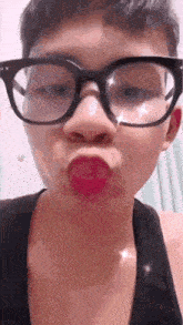 a man wearing glasses and red lipstick is making a face .