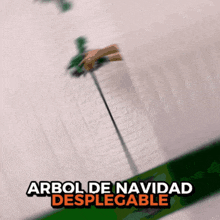a blurry picture of a christmas tree with the words arbol de navidad desplegable