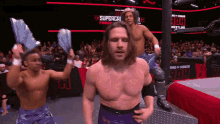 three wrestlers are standing in front of a ring that says roh wrestling