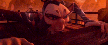 a cartoon character is laying on a table in a dark room with a red background .
