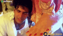 a man is kneeling down next to a woman 's feet in a video .