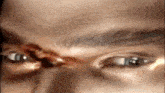 a close up of a person 's face with a bullet hole in the forehead .