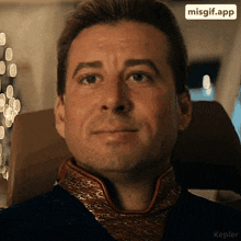 a man with a scarf around his neck is smiling with a misgif app icon above his head