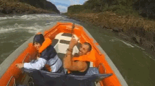 a man and a woman are riding a boat down a river