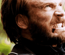 a close up of a man 's face with a beard making a funny face .