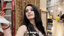 a woman says i 'm hungry while holding a piece of paper
