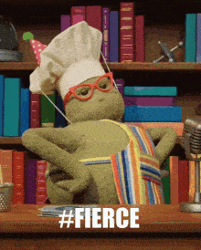 a stuffed animal wearing a chef 's hat and apron says #fierce on the table