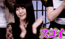 a woman in a maid costume is smiling and clapping her hands