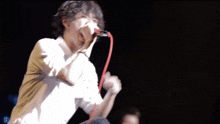 a man singing into a microphone with the letter d in the background