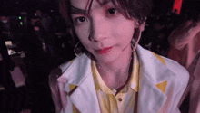 a close up of a person 's face with a necklace and hoop earrings .