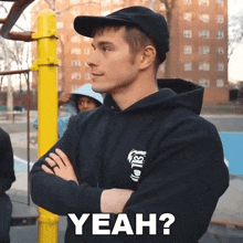 a man with his arms crossed is wearing a black hoodie with the word yeah on it
