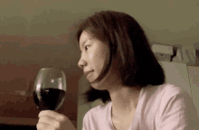 a woman is holding a glass of wine in her hand