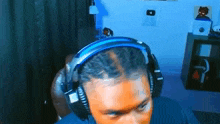 a man is wearing headphones while sitting in a chair in a room .